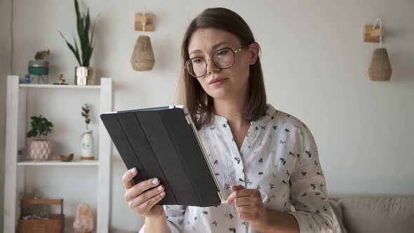 Woman Talking and Using Digital Tablet at Home at Video Conference