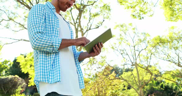 Man using digital tablet in park