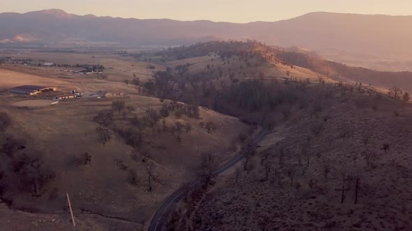 Aerial pull back of winding road in California Tehachapi mountains at sunrise