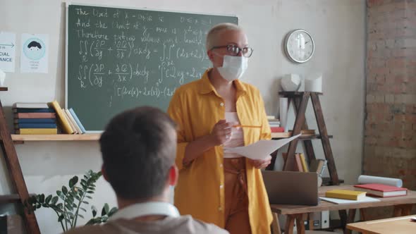 Woman in Mask Teaching Students during Pandemic