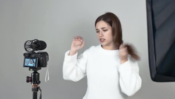 Caucasian Girl Blogger Speaks in Front of Camera Straightens Her Hair Gestures