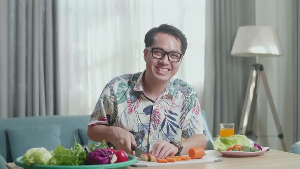 Asian Man Smiling To Camera While Cook Healthy Food At Home