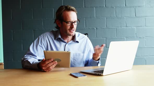 Businessman interacting with client over video calling on laptop