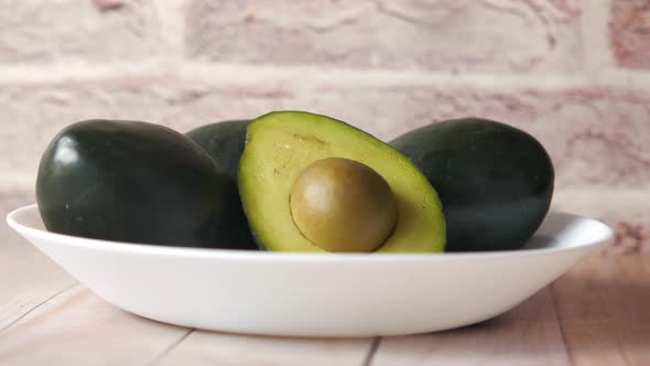 Pouring Honey on a Slice of Avocado on Wooden Table