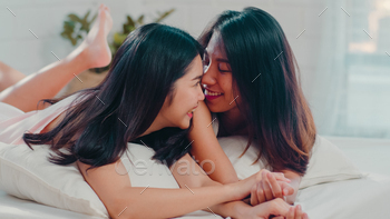 若いアジアの恋人の女性の幸せは、ベッドに横たわっている間に目が覚めた後、一緒に休息をリラックスします。 / Photodune, Misc