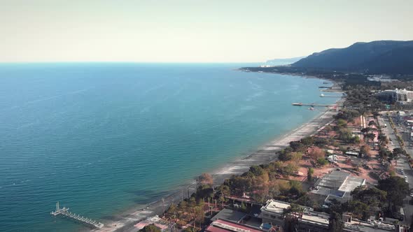 Coastline with sandy beach, mountains and calm tranquil sea.