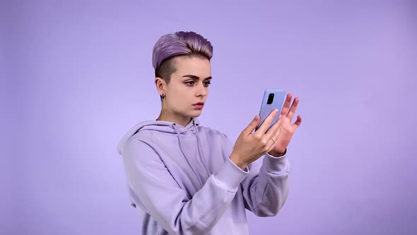 Young Woman in Purple Reading Shocking News at Internet Grabbing Head