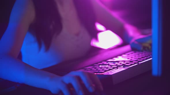 Young Woman in Glasses Playing Online Games in Neon Gaming Club - Mouse and Illuminated Keyboard