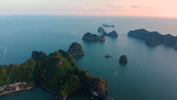 Aerial: flying over Cat Ba and Ha Long Bay rock pinnacles at sunset, Vietnam tourism destination