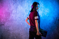 Female esports gamer posing with a gaming gear in neon light. Streamer girl standing with a gaming - PhotoDune Item for Sale