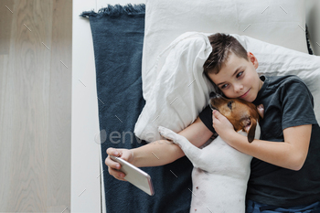 A young boy with a dog in a cozy interior. / Photodune, Misc