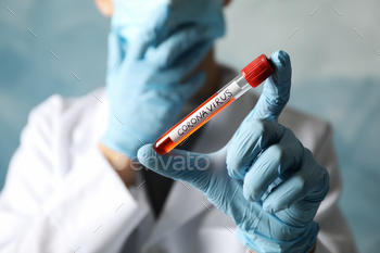 Doctor in protective mask holds positive blood test on Coronavirus. Healthcare and medical concept / Photodune, Misc