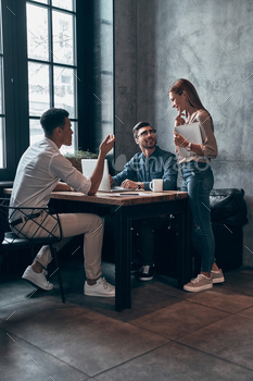 Group of young modern people in smart casual wear discussing something while working in office / Photodune, Misc