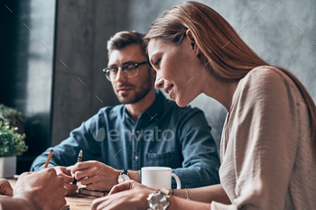 Young modern people in smart casual wear discussing something while working in office together / Photodune, Misc