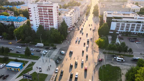 City traffic street crossroad in the rays of the setting sun. Drone footage