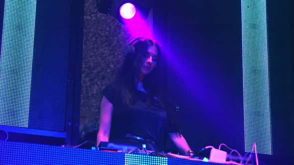 DJ on Stage in Disco Night Club Mixing Techno Music Beat