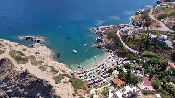 Drone aerial view of Mediterranean village beach on Crete, Greece. Hotel beach vacation concept