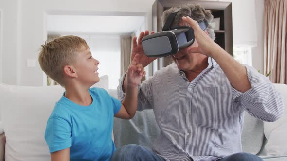 Senior man wearing a Virtual Reality headset with her grandson