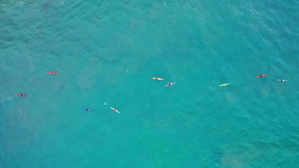 A Group of Sportsmen in Colorful Kayaks Are in the Calm Teal Open Ocean, 