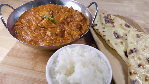 Slider Shot of Eating an Homemade Indian Curry in a Balti Dish with Rice and Butter Naan Bread