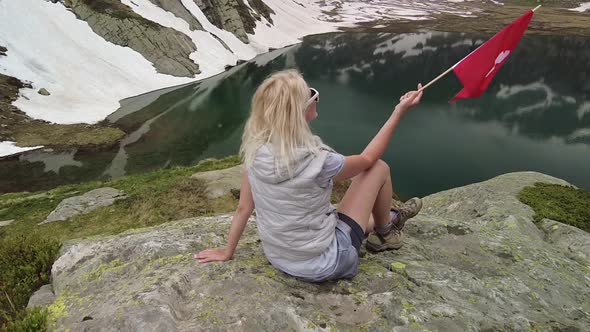 Tourist Woman at Robiei Lake with Swiss Flag