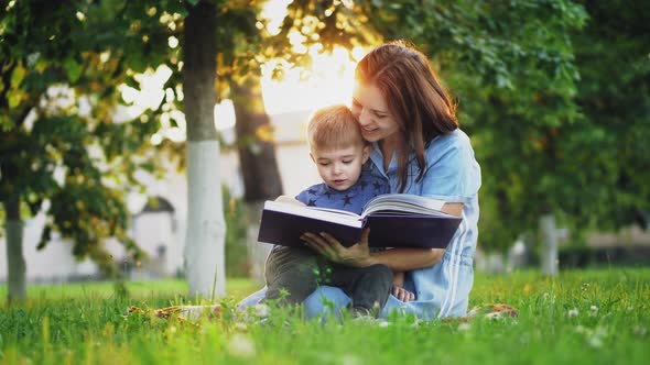 Lovely Mother Reads a Book To Her Little Son