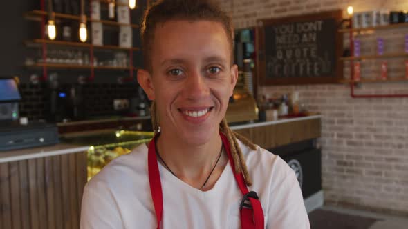 Portrait of mixed race barista with dreadlocks looking at the camera and smiling