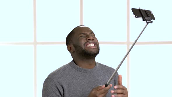 Funny Afro-american Guy Taking Selfie with Monopod.