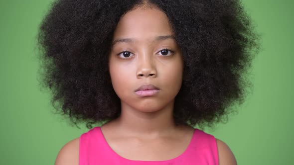 Young Cute African Girl with Afro Hair Against Green Background