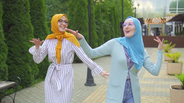 Two Positive Muslim Young Women Dancing in the Park Close Up