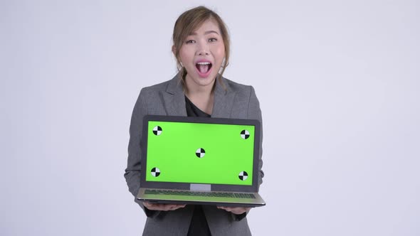 Young Happy Asian Businesswoman Showing Laptop and Looking Surprised