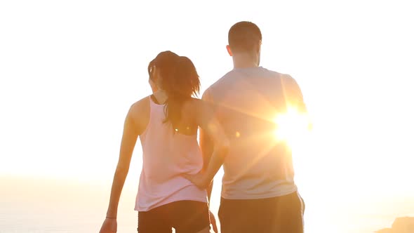 A young couple admiring a scenic view during sunset.