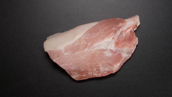 Freezing a pork steak on black table