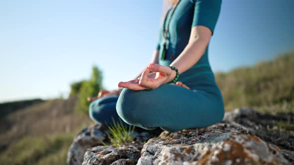 Relaxed Peaceful Yogi Woman Sitting in Lotus While Meditating Feeling Free in Front of Wild Nature