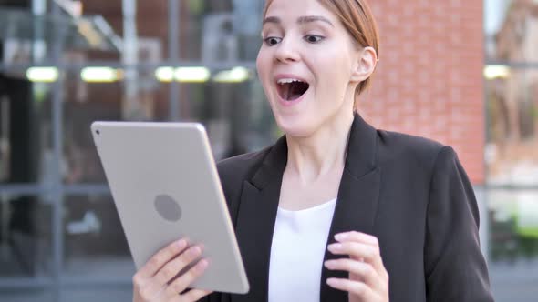 Young Businesswoman Cheering for Success on Tablet Outdoor