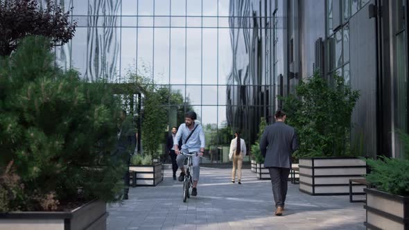 Office Manager Riding Bicycle in Helmet at Business District