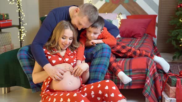 Beautiful Happy Family in Pajamas in the New Year's Bedroom