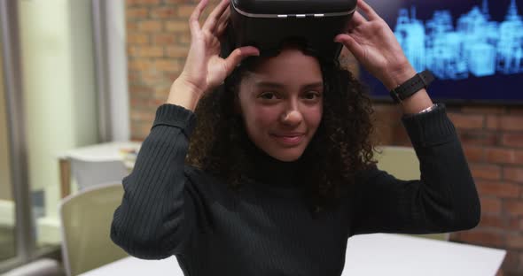 Creative businesswoman using virtual reality headset in modern office