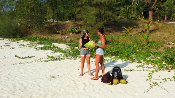 Beautiful beauty models travelling spending quality time at the beach on clean white sand and blue b