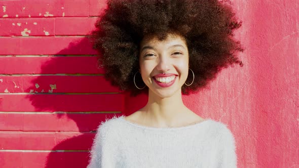 Beautiful woman in front of red wall smiling happily