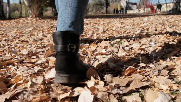 Female Legs Walking on Fallen Autumn Leaves in the Park in Slow Motion