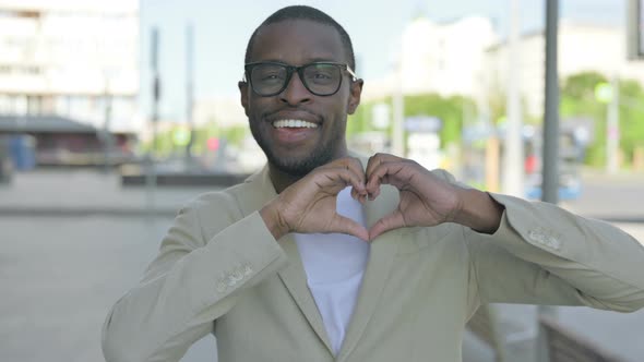 Loving African Man Showing Heart Shape By Hands Outdoor