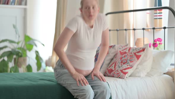 Pregnant Woman Standing Up and Leaving Bedroom