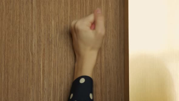 Closeup Female Hand Banging on the Wooden Door