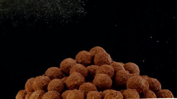 Candy Pyramid of Raw Chocolate Truffles Covering with Gold Luster Dust, Slow Mo