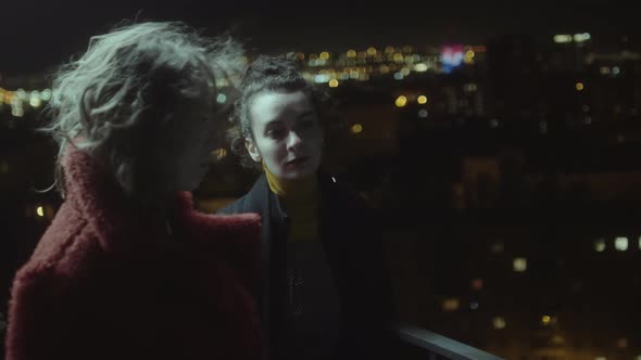 Two Women on Urban Roof at Night