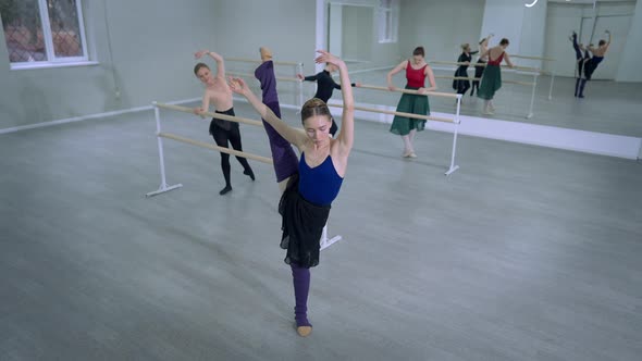 Wide Shot Flexible Slim Young Ballerina Putting Leg Down Looking at Camera Smiling