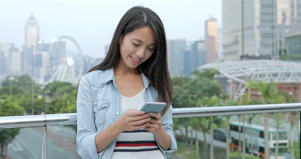 Woman using smart phone in the city