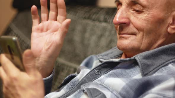 A pensioner communicates using a smartphone in a video chat.