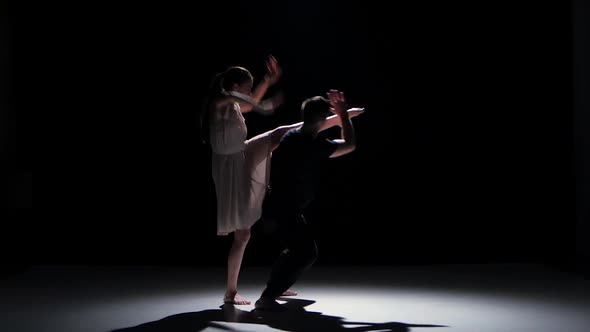 Man and Woman Start Performing a Contemporary Dance on Black, Shadow